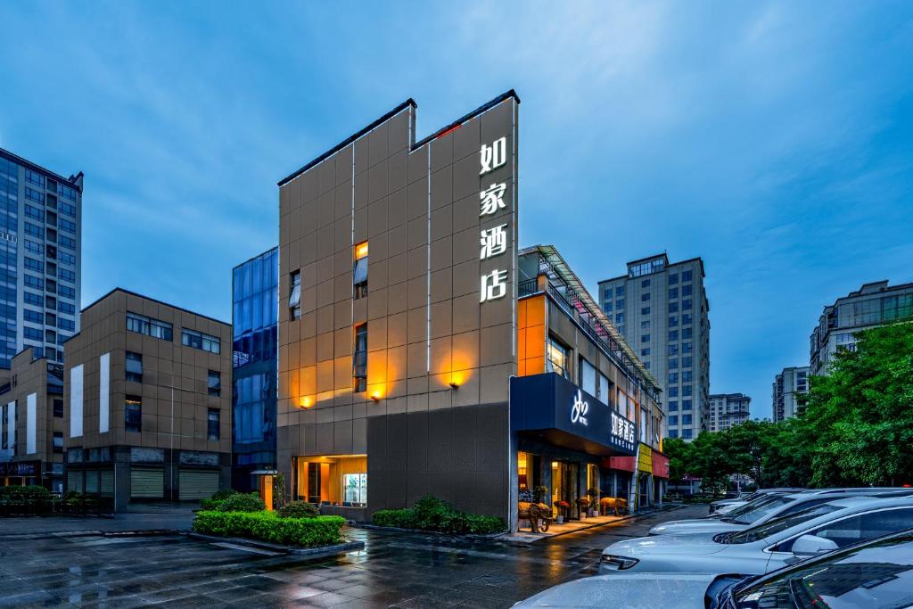 un edificio in una strada cittadina con auto parcheggiate di Home Inn Zhangjiajie Tianmen Mountain Branch a Zhangjiajie