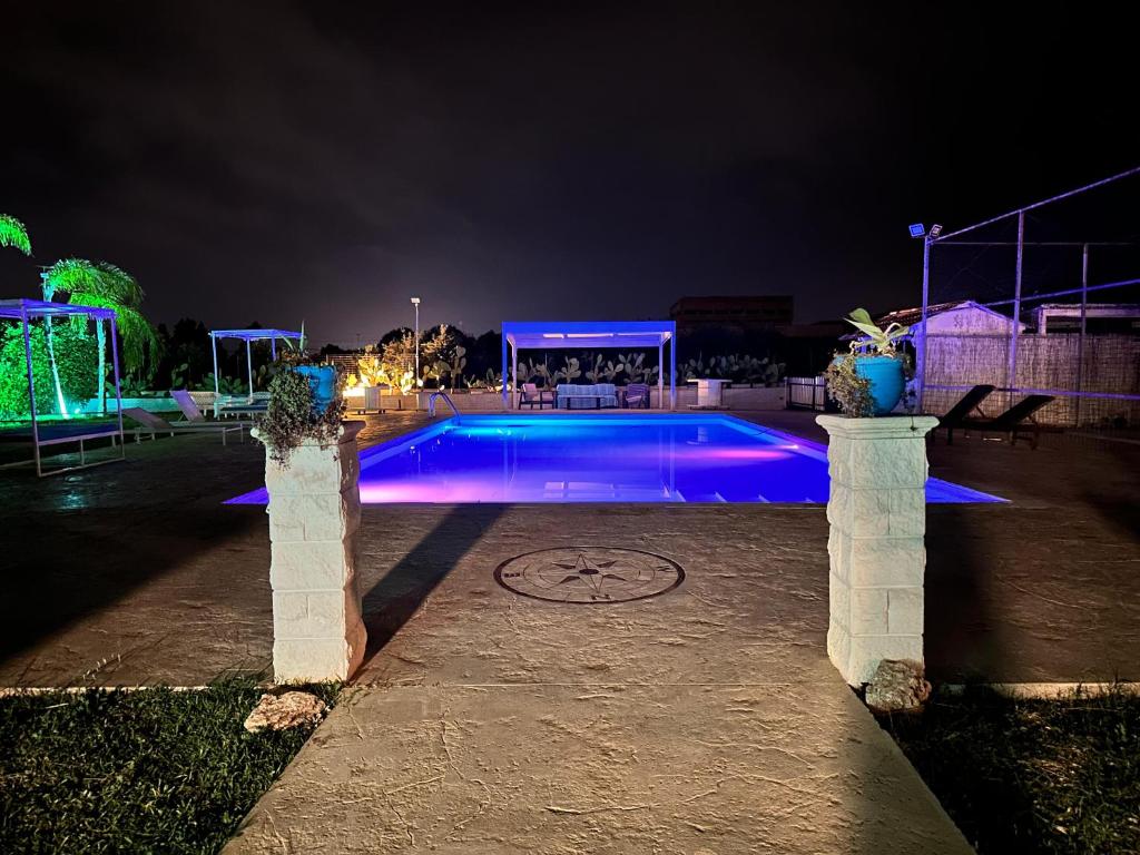 a swimming pool at night with blue lights at casa croma in Siracusa