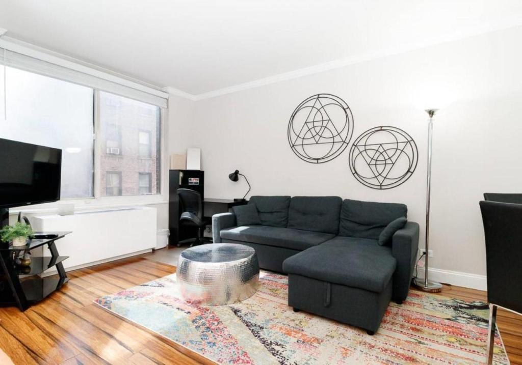 a living room with a couch and a tv at Beautiful Studio Apt in NYC! in New York