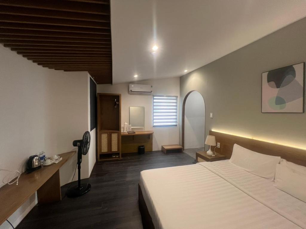 a bedroom with a bed and a desk in a room at A25 Hotel - 14 Hồ Huấn Nghiệp in Ho Chi Minh City
