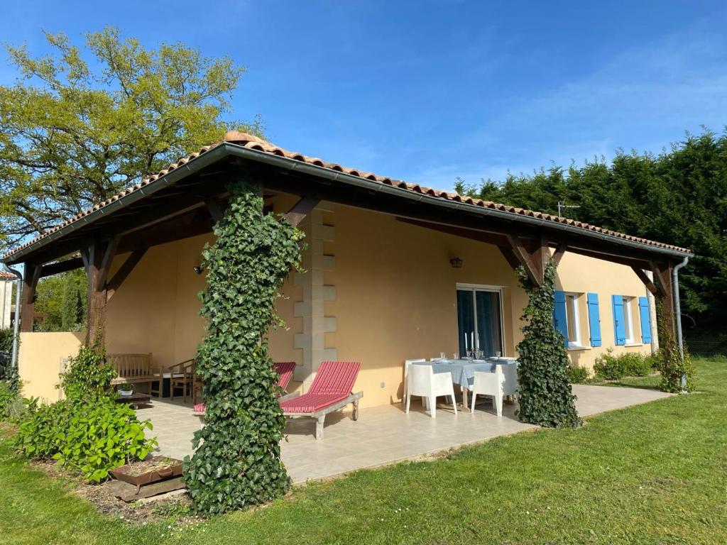 une maison avec un patio avec une table et des chaises dans l'établissement Private Luxury Villa With Big Garden on Park With Swimming Pool - Golf Resort and Restaurant nearby, à Vasles