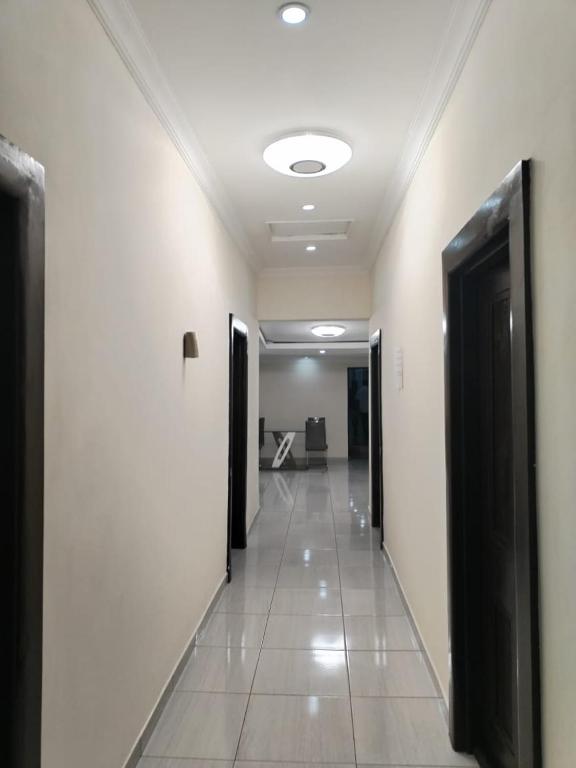 a hallway of a building with black doors and tile floors at DBright Lodge in Pretoria
