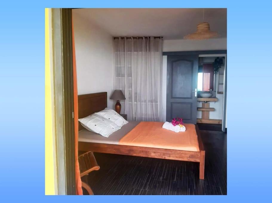 - une chambre avec un lit doté d'un cadre en bois dans l'établissement NEW Joli Studio avec Vue mer imprenable - wifi, à Saint-Leu