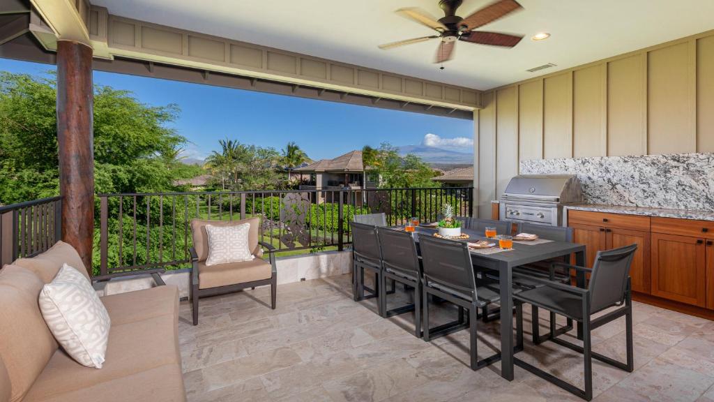 a patio with a table and chairs on a balcony at MAUNA KEA SUNRISE Distinguished 4BR KaMilo Home with Private Beach Pass in Waikoloa