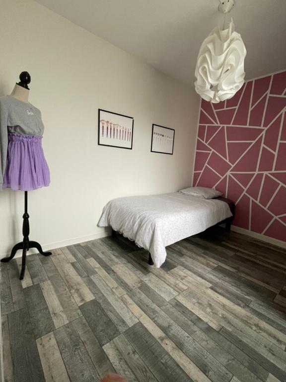 1 dormitorio con cama y pared de color rosa en Douce nuit en Saint-Nicolas-dʼAliermont