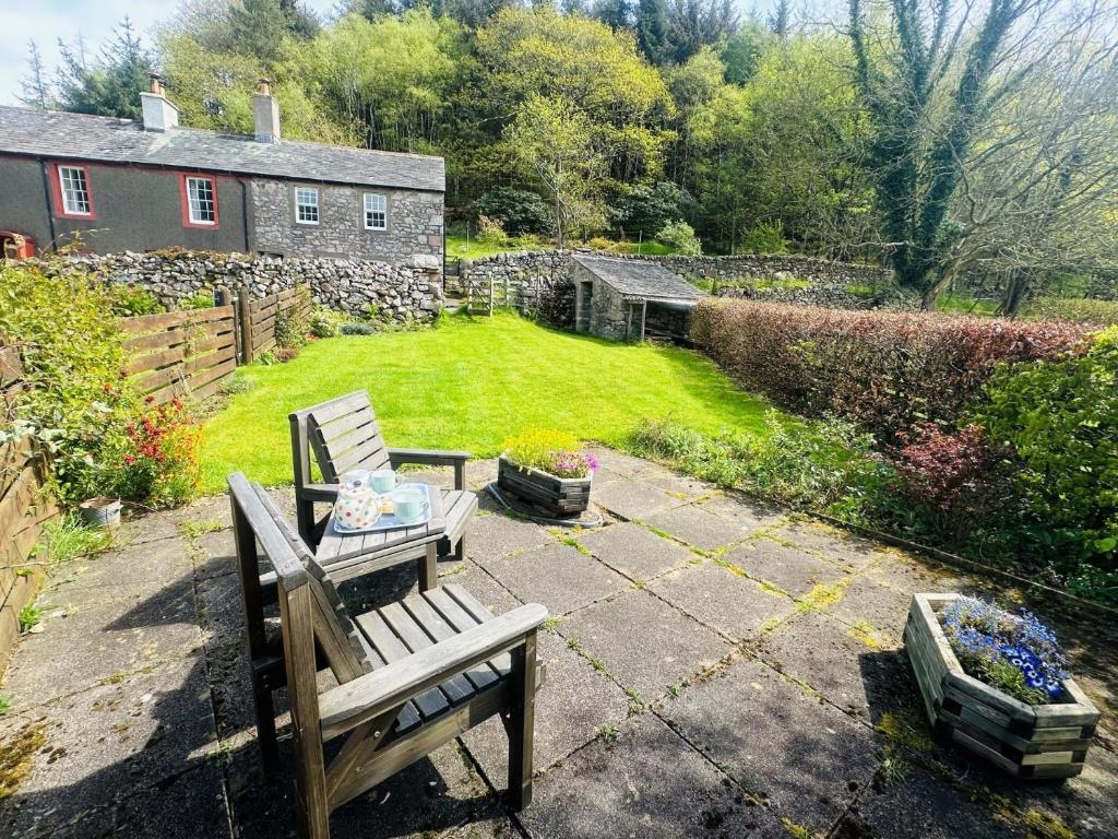 a garden with a bench and a yard with a house at 1 Bed in Eskdale 87247 in Eskdale