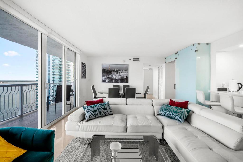 a living room with a large white couch and a living room at Bnb Hyperion - Ocean View - 3BR Condo w Pool & GYM in Miami