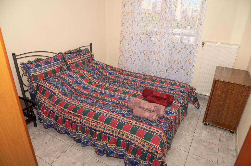 Cette chambre comprend un lit avec une couverture et une commode. dans l'établissement Stella's Apartment, à Alexandroúpolis