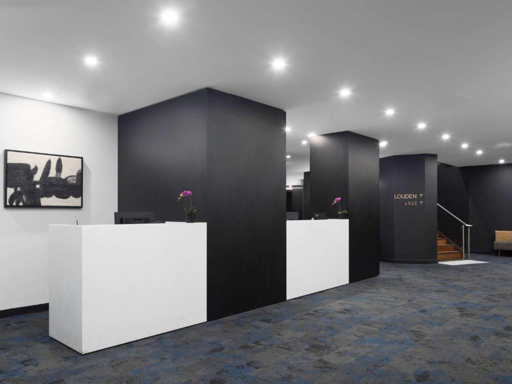 a lobby with black and white walls and tables at Mercure Welcome Melbourne in Melbourne