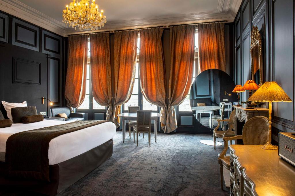 um quarto de hotel com uma cama e uma secretária em Best Western Le Cheval Blanc -Vue sur le port-plein centre ville em Honfleur