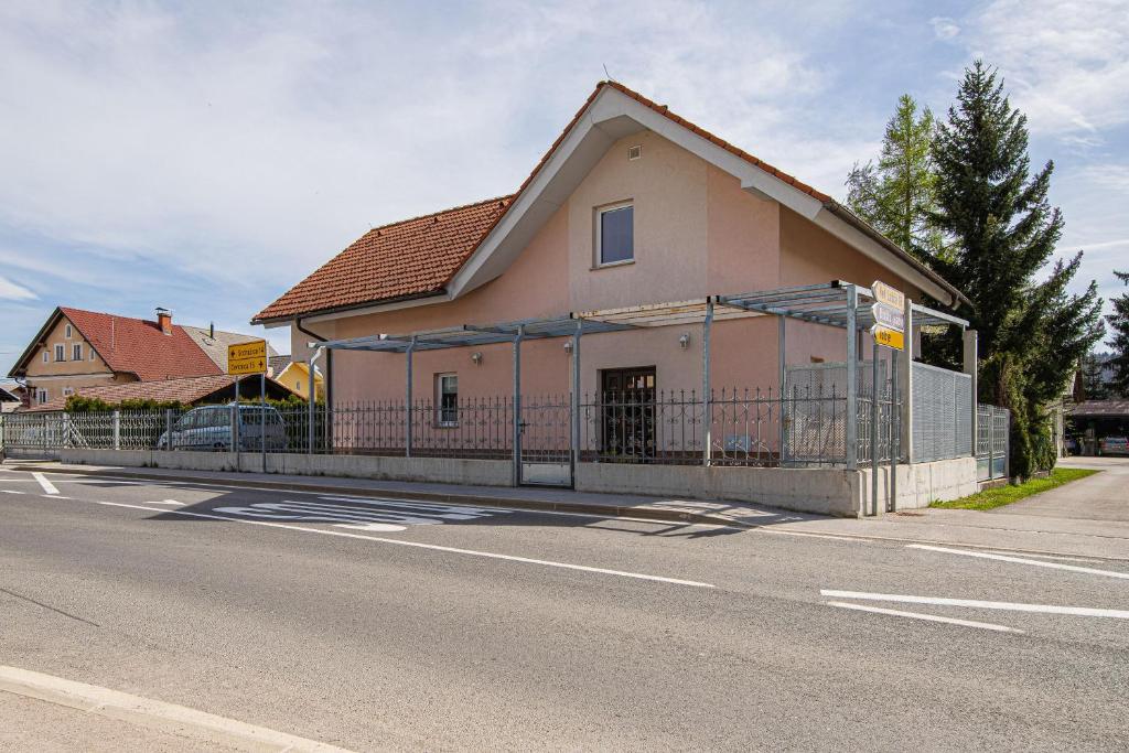 ein Haus an der Seite einer Straße mit einem Zaun in der Unterkunft Apartments Lavrič - Happy Rentals in Velike Bloke
