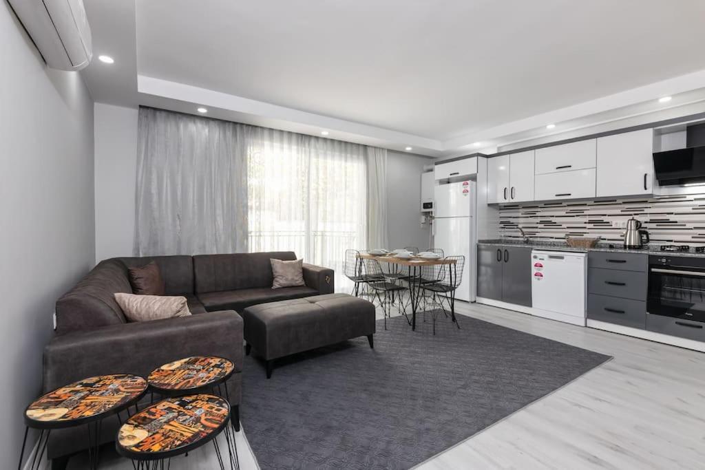 ein Wohnzimmer mit einem Sofa und einer Küche in der Unterkunft 4-3 Yatak Odalı Büyük Daire Kaleiçi Yakını in Antalya