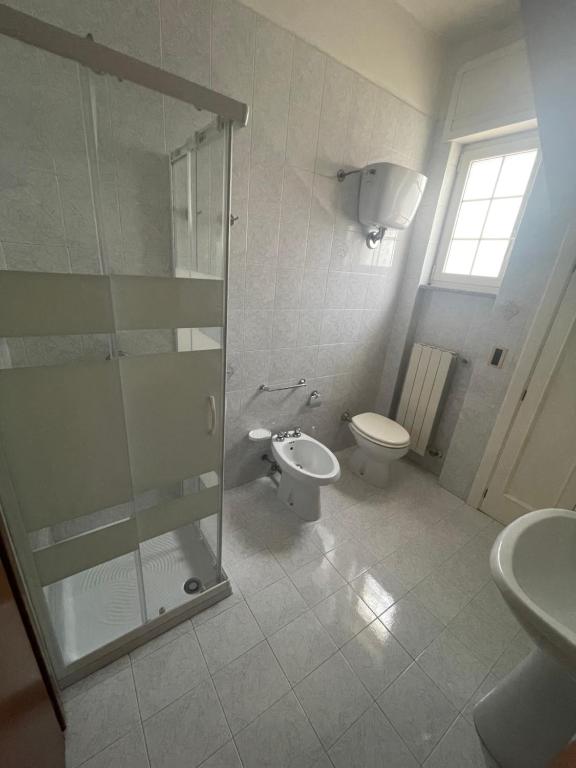 ein Bad mit einem WC und einer Glasdusche in der Unterkunft Dolce Vita Rooms in Lecce