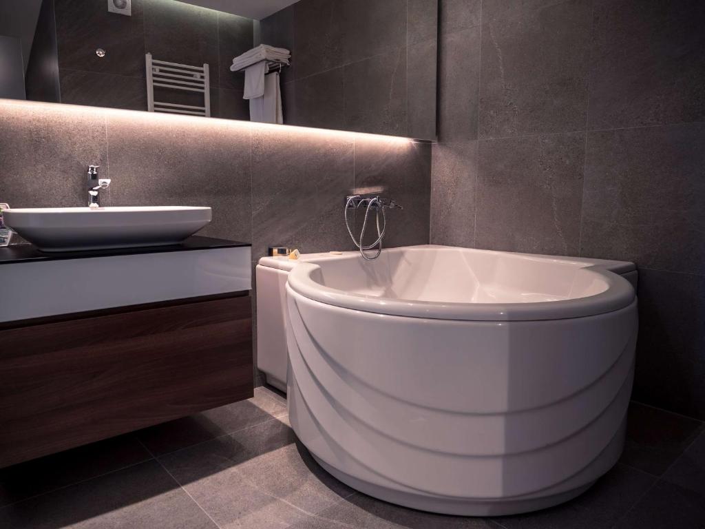 baño con bañera grande y lavamanos en Best Western Premier Natalija Residence en Belgrado