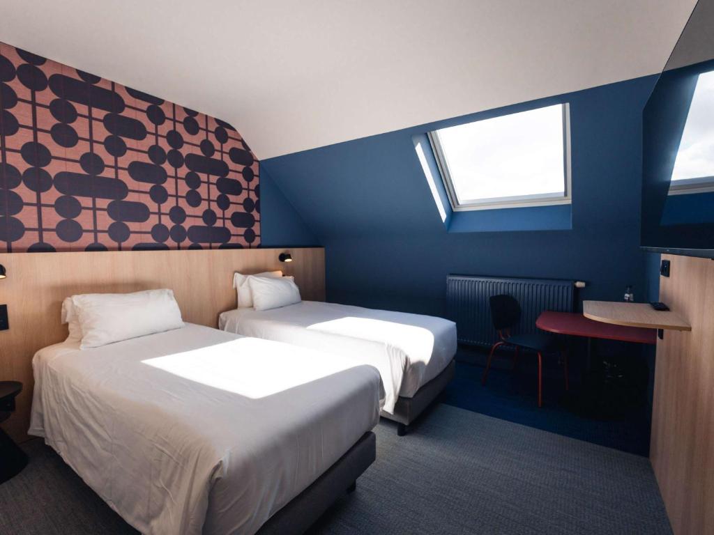 Habitación de hotel con 2 camas y escritorio en Aero44 Hotel Charleroi Airport, en Charleroi