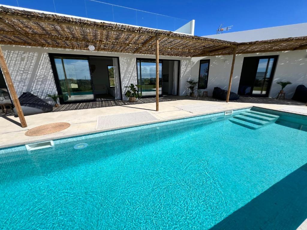 a swimming pool in front of a house at Villa con piscina en Golf Isla Canela Links in Ayamonte