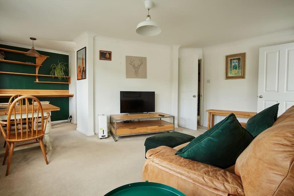 een woonkamer met een bank en een televisie bij Premium Central Stroud Apartment with Parking x2 