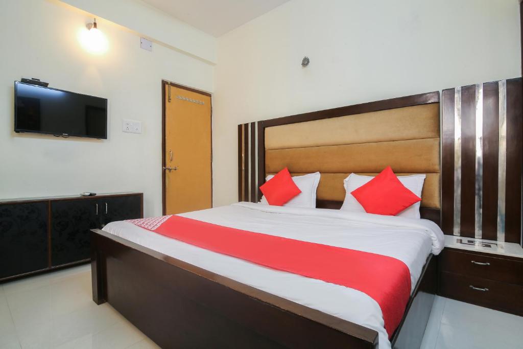 a bedroom with a large bed with red pillows at Flagship Dewa Near Dabolim Airport in Vasco Da Gama