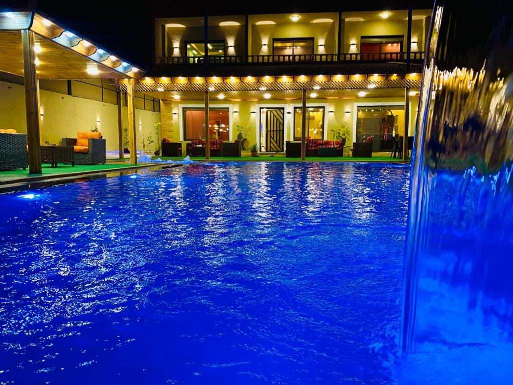 ein Pool in der Nacht mit blauen Lichtern in der Unterkunft Royal eagle in Al Rama