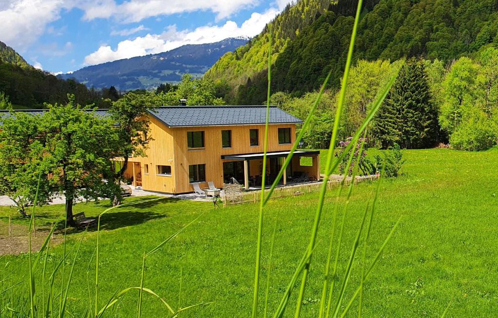 ein Haus mitten auf einem grünen Feld in der Unterkunft Haus Valtellina in Galgenul