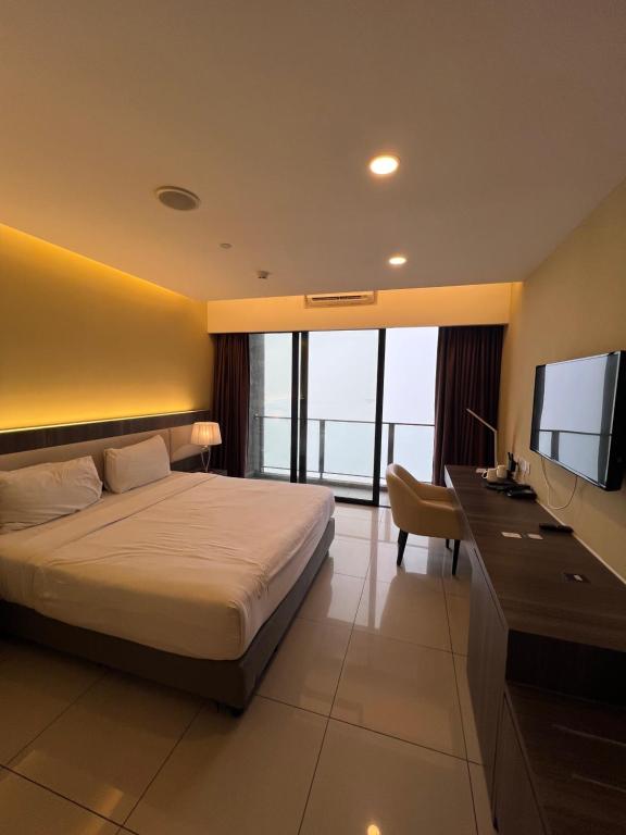 a bedroom with a bed and a flat screen tv at Grand Ion Delemen by 91 Homestay in Genting Highlands