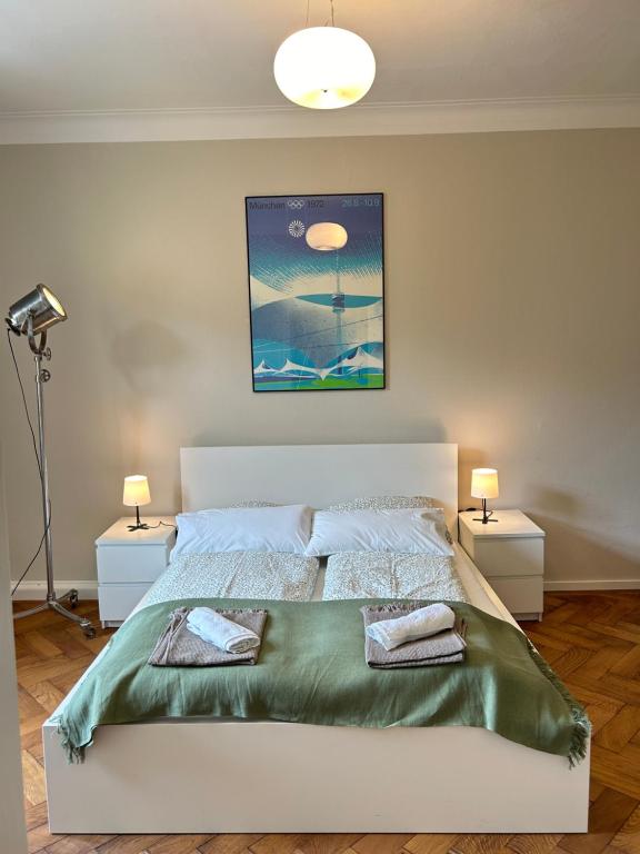 ein Schlafzimmer mit einem großen weißen Bett mit zwei Lampen in der Unterkunft Welcome to Künstlerflair in München