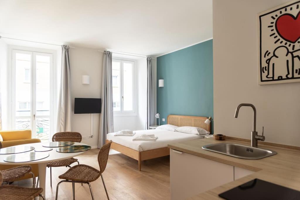 ミラノにあるYouhosty - Ticinese Suite 1のキッチン、リビングルーム(ベッド1台、テーブル付)