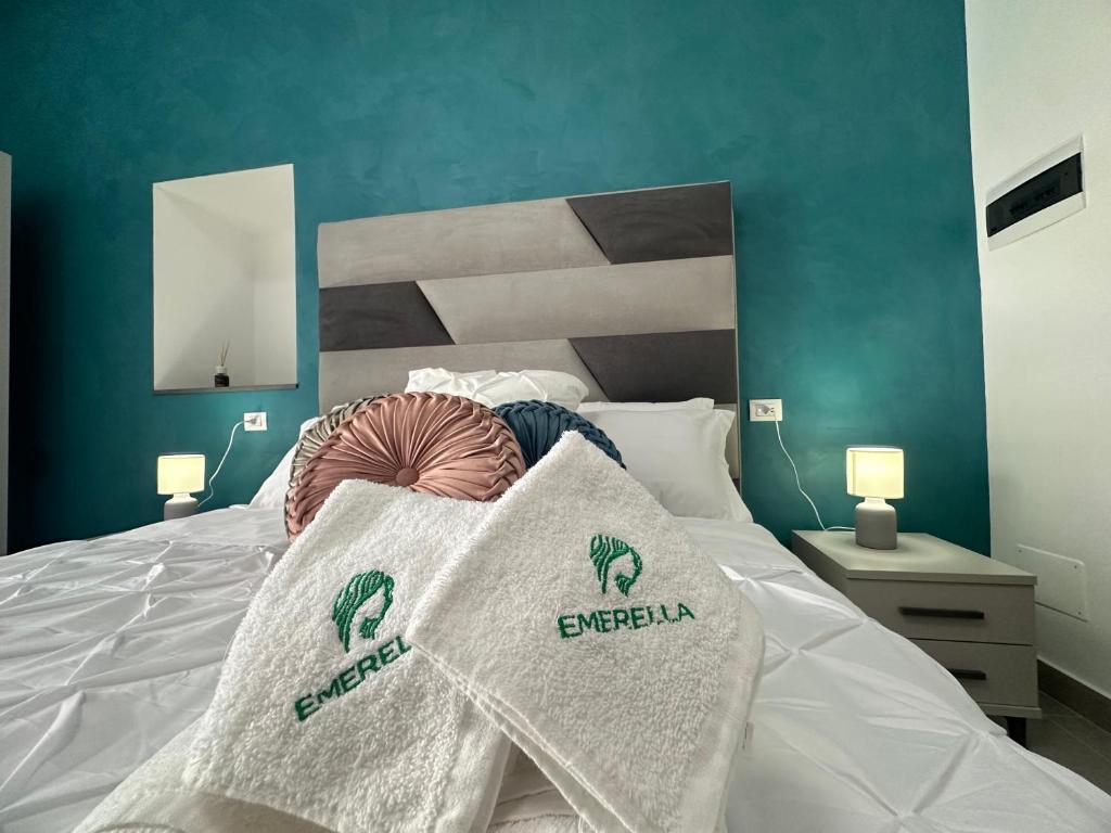 a bed with two white pillows on top of it at Emerella Luxury Suites-Siderno Lungomare in Siderno Marina
