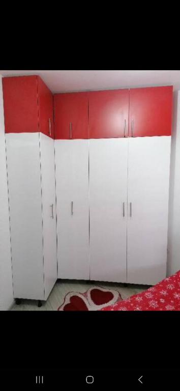 Stella rossa في Modriča: غرفة بها دواليب بيضاء وجدار احمر