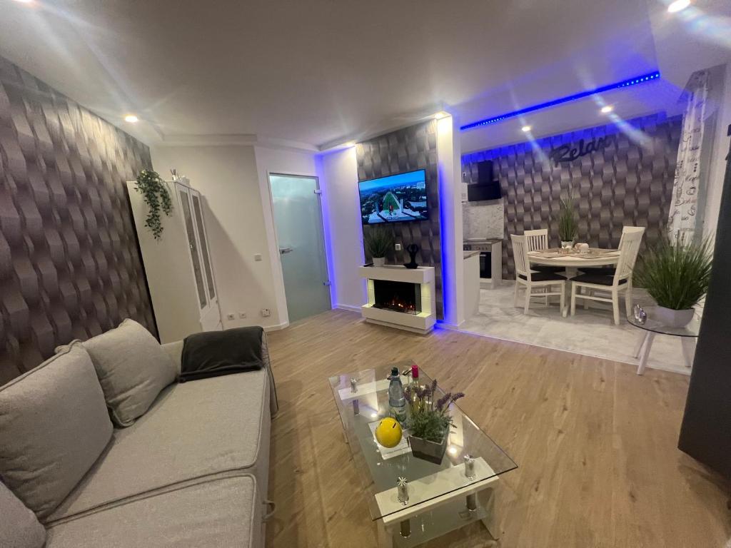 een woonkamer met een bank, een tv en een tafel bij Ferienwohnung Viktoria in Gotha