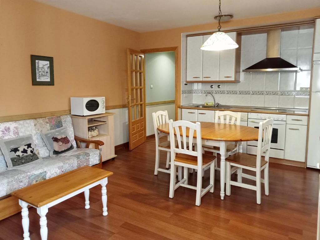 cocina y sala de estar con mesa y sofá en Apartamentos Gavín Biescas 3000, en Gavín
