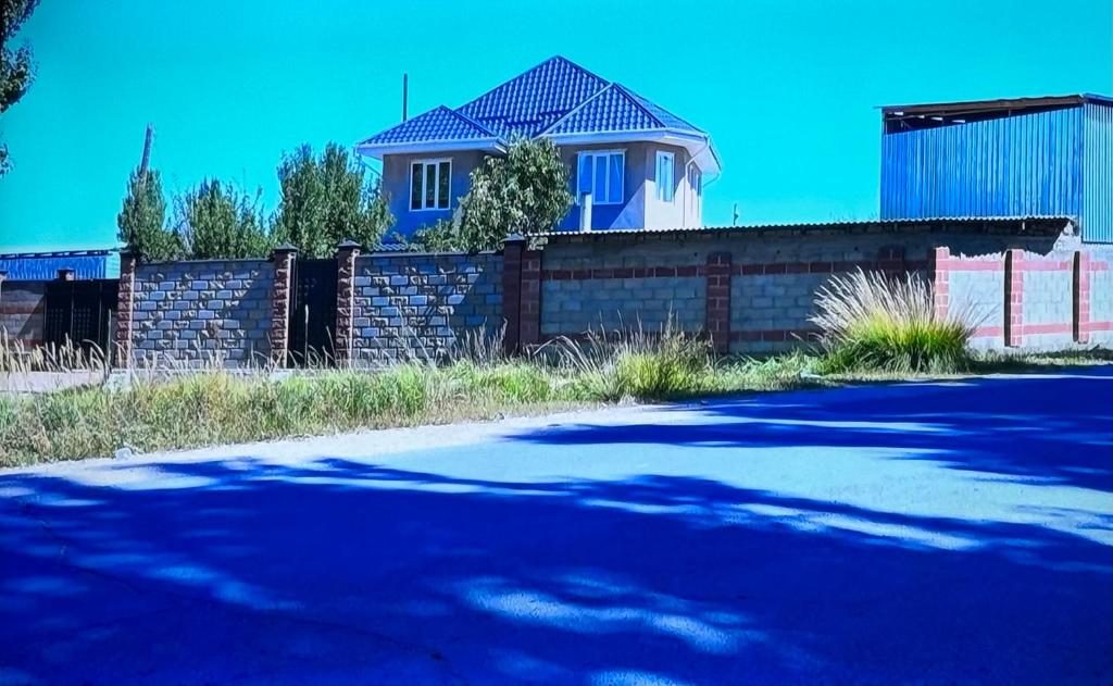 科奇科尔Guest House Umar的街道前有围栏的房子