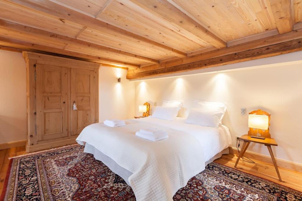 Schlafzimmer mit einem großen weißen Bett und einer Holzdecke in der Unterkunft Gîte Bei der Kirche 4 étoiles in Mundolsheim