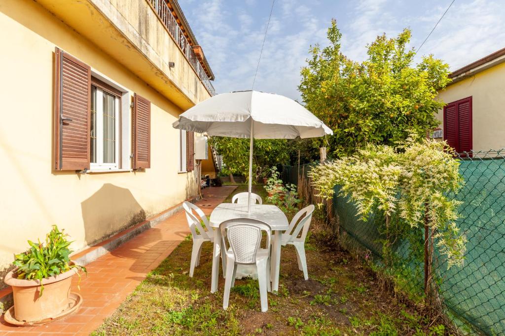 eine Terrasse mit einem Tisch, Stühlen und einem Sonnenschirm in der Unterkunft Casa vacanza Massa in Massa
