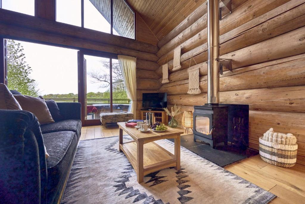 uma sala de estar com lareira num chalé de madeira em Alder Lodge with Hot-tub em Carlisle