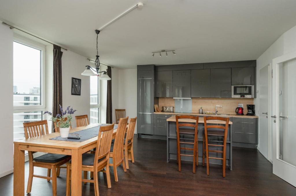 uma cozinha e sala de jantar com uma mesa de madeira e cadeiras em Holiday at Alexanderplatz Apartments em Berlim