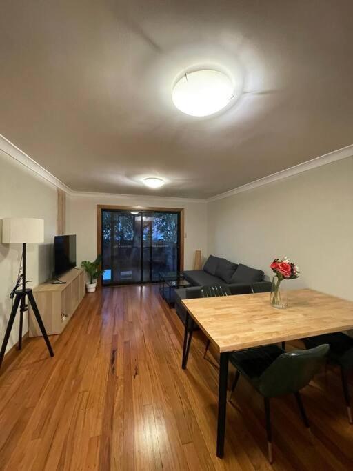 a living room with a table and a couch at Comfortable 3 Bedroom House Pyrmont in Sydney