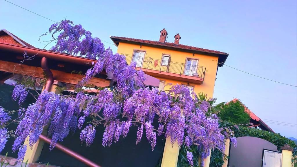 una corona de flores púrpuras colgando de un edificio en B&B Villa S Anna Hospitality Solutions, en Arquata Scrivia