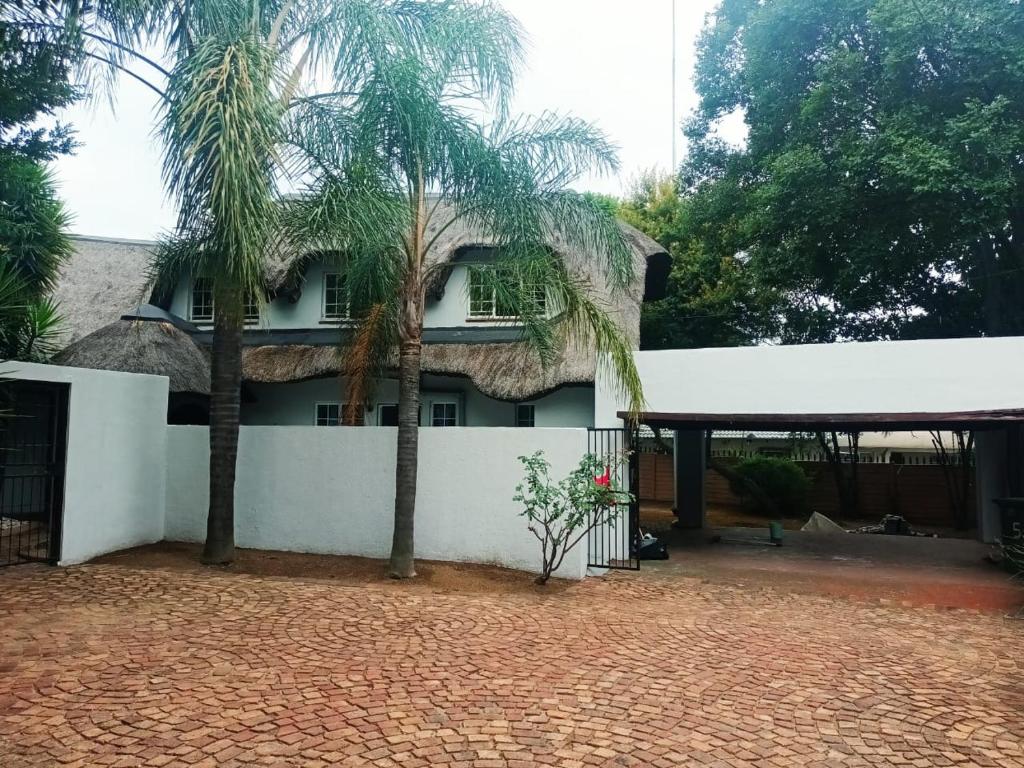 a house with two palm trees in front of it at Mandy place in Sandown