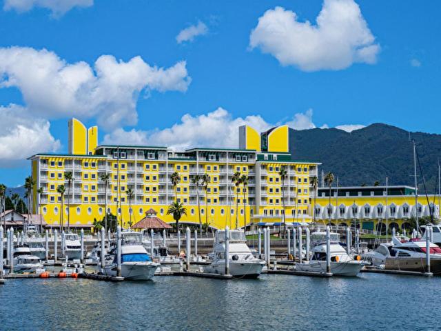 ein gelbes Hotel mit Booten, die in einem Yachthafen angedockt sind in der Unterkunft Wakayama Marina City Hotel in Wakayama