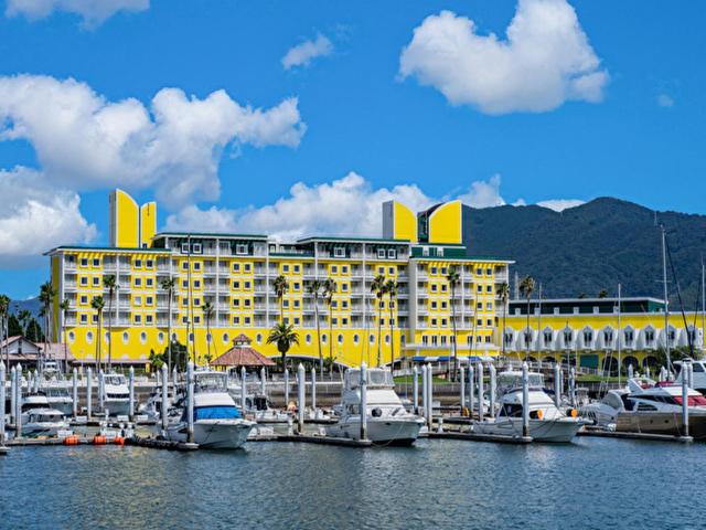 a yellow hotel with boats docked in a marina at Wakayama Marina City Hotel in Wakayama