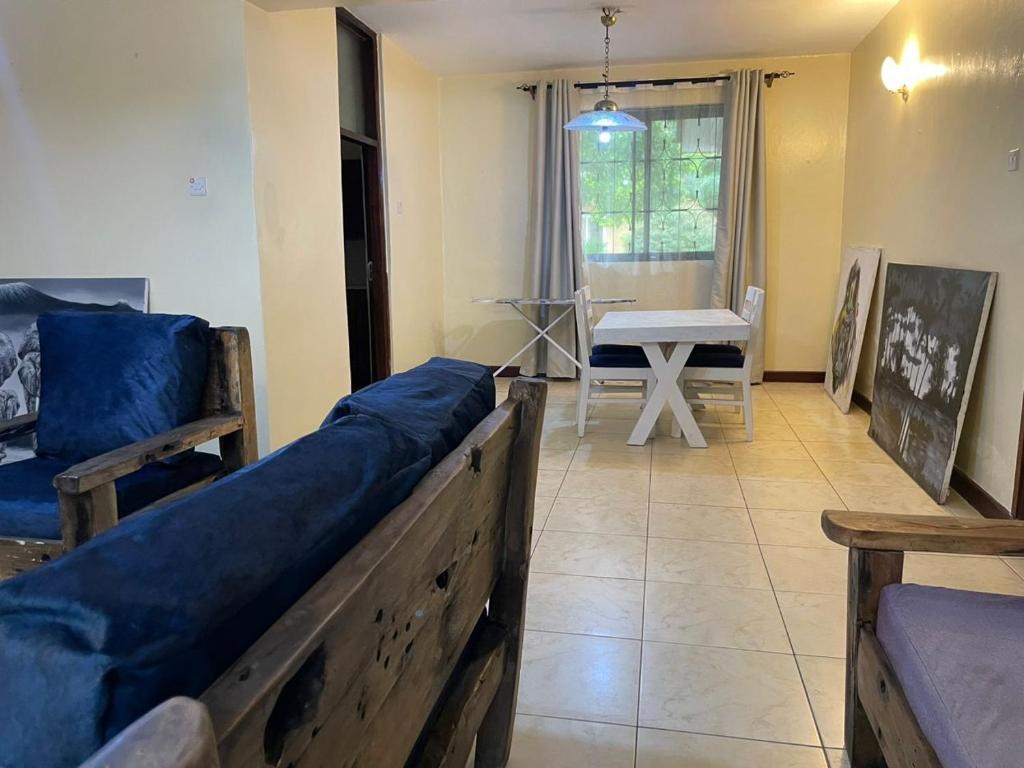 Sala de estar con 2 camas y mesa en Tranquility three bedroom house with Wi-Fi, en Dar es Salaam