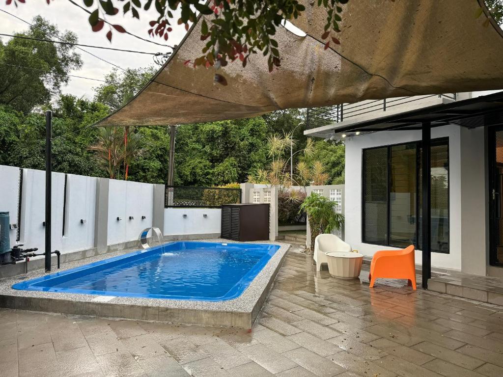 - une piscine avec une chaise orange et un parasol dans l'établissement Corner New Private Pool Villa Near Sunway up to 30 pax, à Subang Jaya