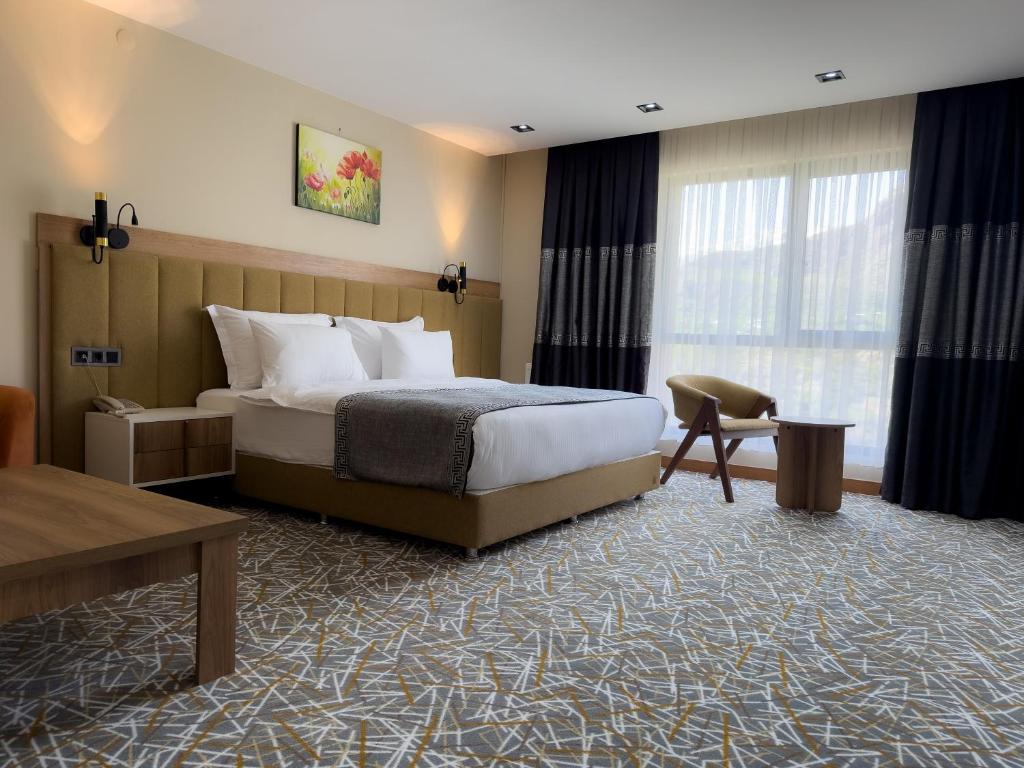 ein Hotelzimmer mit einem Bett und einem Tisch in der Unterkunft Beyt Managed By Dedeman in Şırnak
