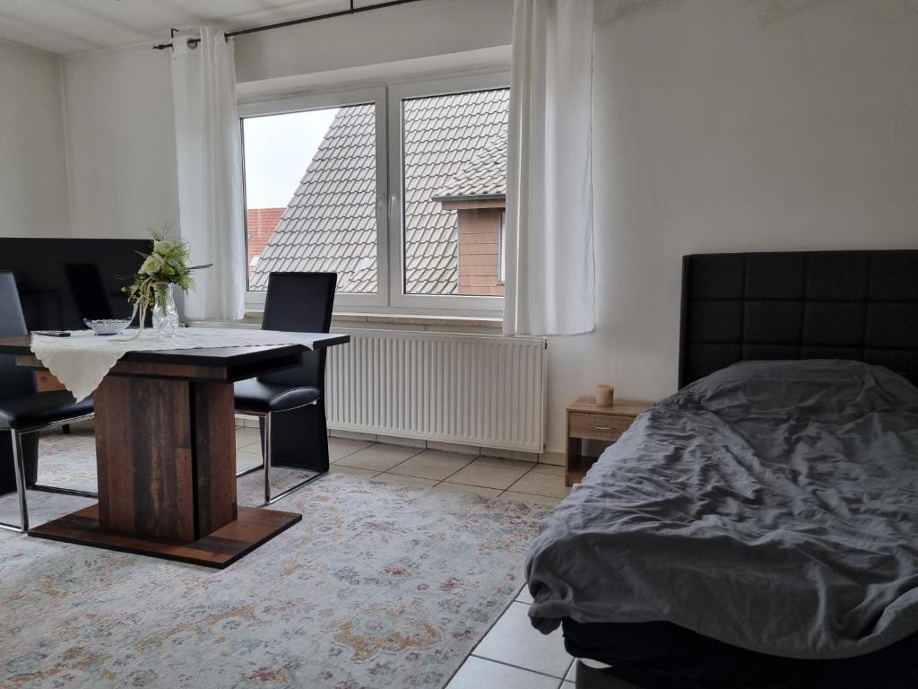 um quarto com uma mesa, uma cama e uma janela em Bocholt Apartment Ferienwohnung em Bocholt