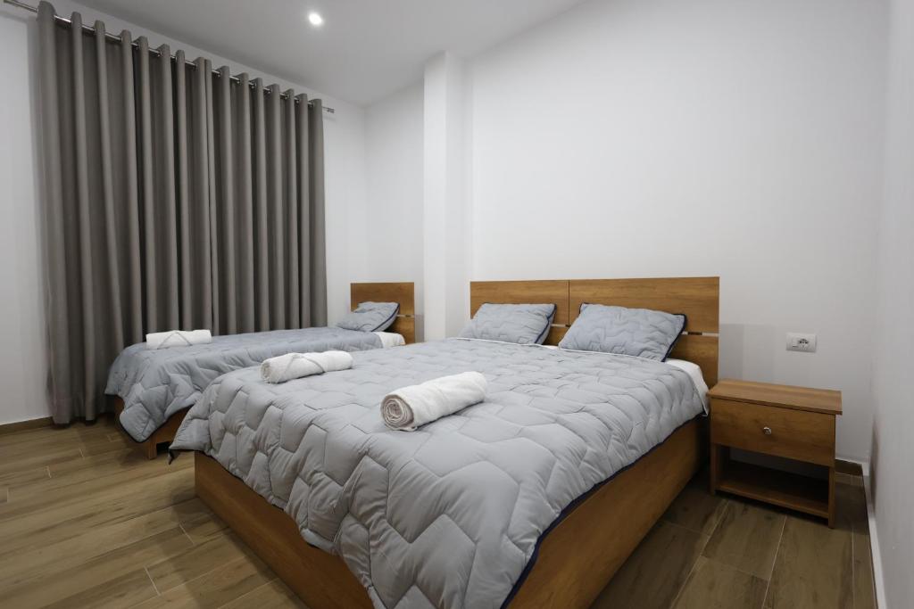 ein Schlafzimmer mit 2 Betten und Handtüchern darauf in der Unterkunft Guesthouse Aurel in Berat