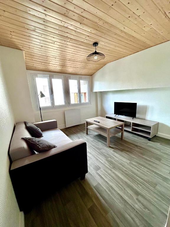 un salon avec un canapé et une table dans l'établissement appartement 2 pieces, à Aurillac