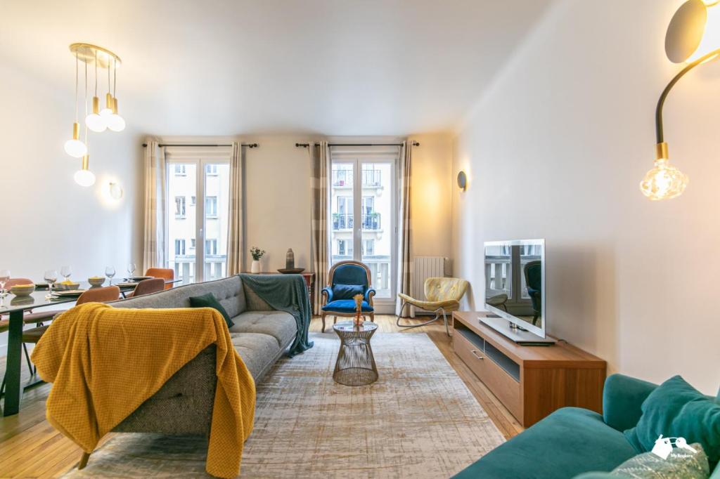 - un salon avec un canapé et une télévision dans l'établissement MBA - Paris 17 - Luxury Appart, à Paris