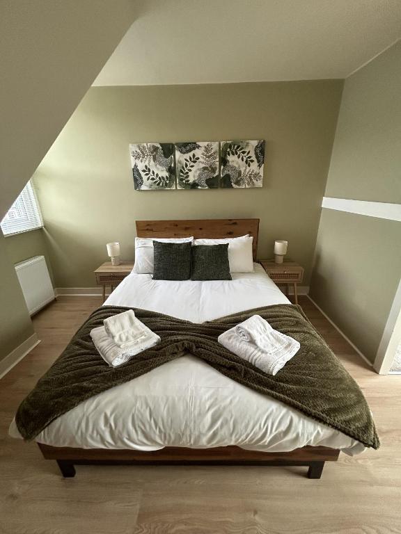 a bedroom with a large bed with two pillows at Kensington Park in Reading