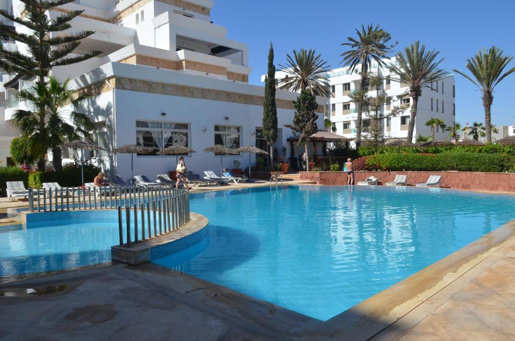 a swimming pool in front of a building at Residence Intouriste in Agadir